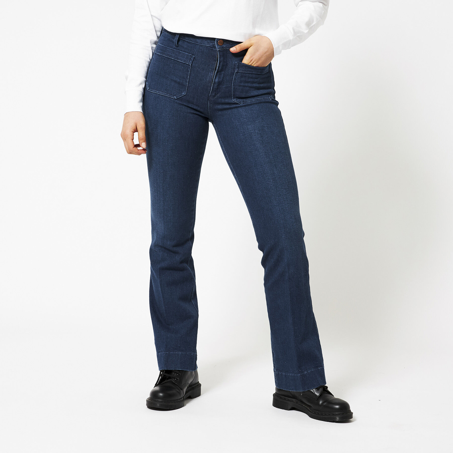 Femme blonde attrayante portant un jean à jambes évasées, escarpins à
